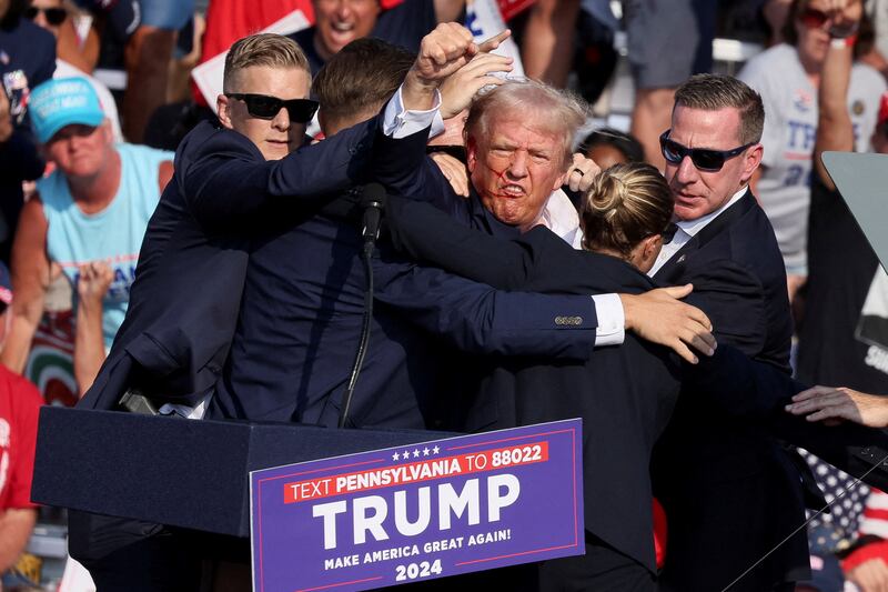 Republican presidential candidate and former U.S. President Donald Trump gestures with a bloodied face 