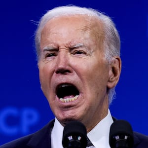 Joe Biden yells while speaking on stage at a conference.