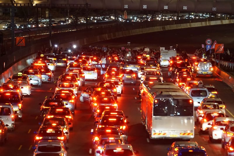 A group of protestors block traffic on a highway