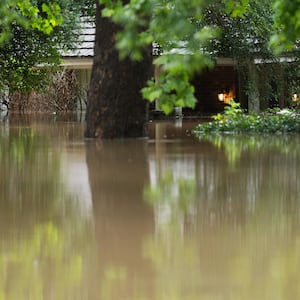 A home in River Plantation is seen with its lights on in flood water.