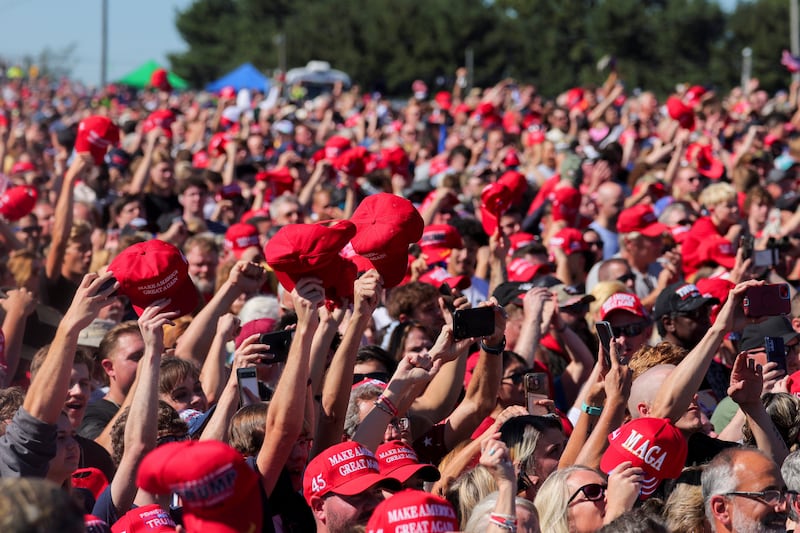 Supporters of Republican presidential nominee and former U.S. president Donald Trump raise MAGA hats, on the day Trump returns for a rally at the site of the July assassination attempt against him, in Butler, Pennsylvania, U.S., Oct. 5, 2024.