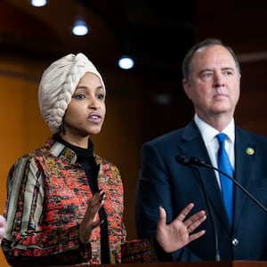 Rep.-elect Ilhan Omar speaks to the press with Rep. -elect Adam Schiff at her right and Rep. -elect Eric Swalwell at her left while they conduct a news conference.