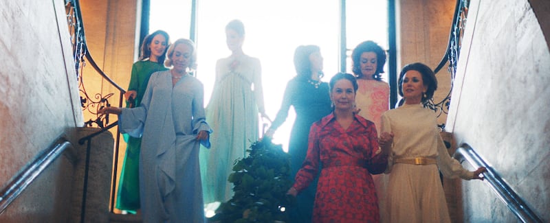 A still from FEUD: Capote Vs. The Swans episode "Ice Water in Their Veins" showing Chloe Sevigny as C.Z. Guest,  Naomi Watts as Babe Paley, Diane Lane as Slim Keith, descending stairs and dressed up glamoursly.