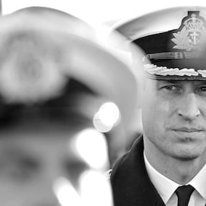 A black and white image of Prince William seen between soldiers