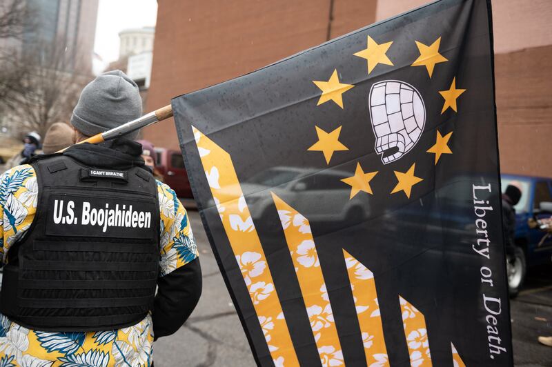 A picture of a Boogaloo Boi seen from behind, wearing a Hawaiian shirt and a bulletproof vest.