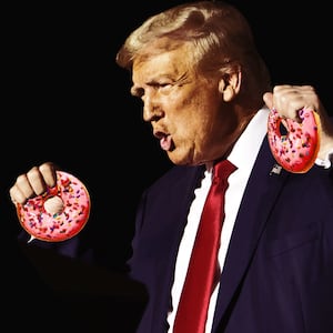 A photo illustration of Donald Trump shouting while holding two pink glazed donuts in both hands.