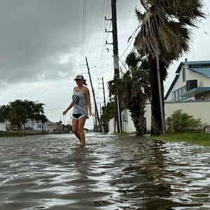 Allison Crane walks out of her flooded neighborhood after Hurricane Beryl passed in Galveston, Texas.