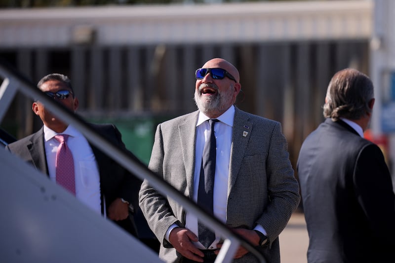 Senior Advisor Chris LaCivita stands on the tarmac wearing sunglasses looking up