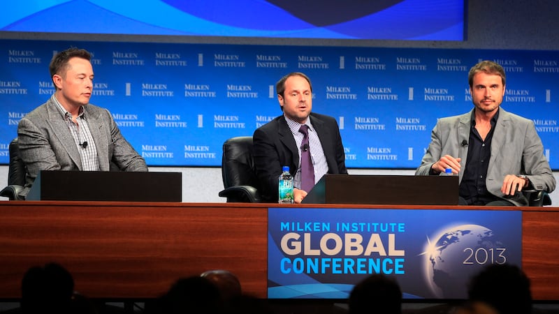 Elon Musk (left), CEO of Tesla Motors and SpaceX, and his brother Kimbal Musk (right), co-founder of The Kitchen Community, appear on a panel discussion with interviewer Jeff Skoll.