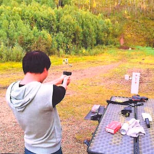 Jun “Harry” Liang shooting a pistol at a firing range in Alaska.