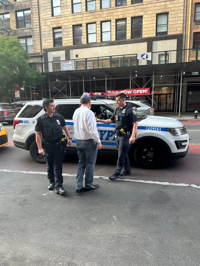 Rabbi Chezky Wolff speaks with police officers responding to the scene. 