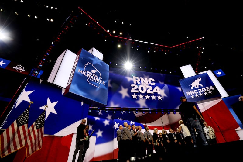 A choir on the stage of the RNC in Milwaukee. Red white and blue branding also spells RNC 2024