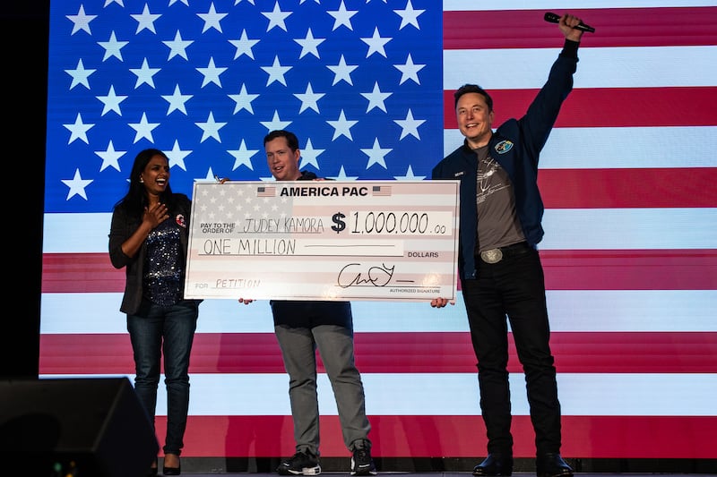 SpaceX and Tesla founder Elon Musk awards Judey Kamora with $1,000,000 during an America PAC town hall on Oct. 26, 2024 in Lancaster, Pennsylvania.