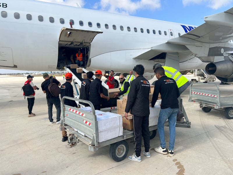 Members of Libya’s Youth Hostels Association unload medical aid that arrived by plane at Al Abraq airport in Al Abraq, Libya, Sept. 12, 2023. 