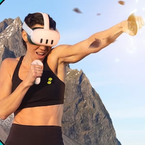 A woman in a meta 3 headset and black workout set punches a virtual target into a million pieces.