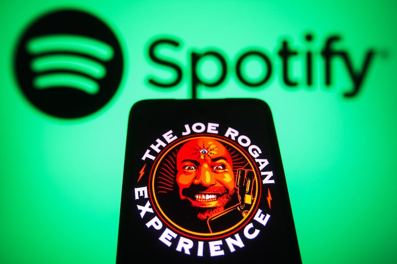 UKRAINE - 2022/02/10: In this photo illustration, The Joe Rogan Experience podcast logo is displayed on a smartphone screen with the Spotify logo in the background. (Photo Illustration by Pavlo Gonchar/SOPA Images/LightRocket via Getty Images)