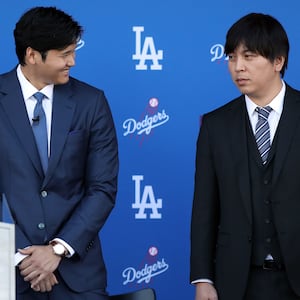 Shohei Ohtani speaks with his interpreter Ippei Mizuhara prior to being introduced by the Los Angeles Dodgers at Dodger Stadium on December 14, 2023 in Los Angeles, California.