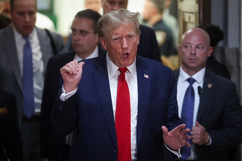 Former President Donald Trump gestures while leaving the courtroom during a break, as he attends the Trump Organization civil fraud trial