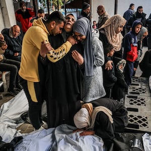 Palestinians mourn after identifying corpses of relatives killed in overnight Israeli bombardment.