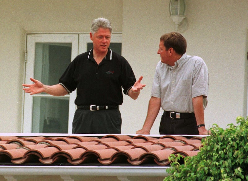 President Bill Clinton speaks with Ron Burkle on the balcony of Burkle's mansion.