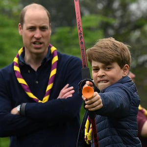 Britain's Prince George of Wales tries his hand at archery as Britain's Prince William, Prince of Wales, watches him, while taking part in the Big Help Out, during a visit to the 3rd Upton Scouts Hut in Slough, west of London, Britain, May 8, 2023.