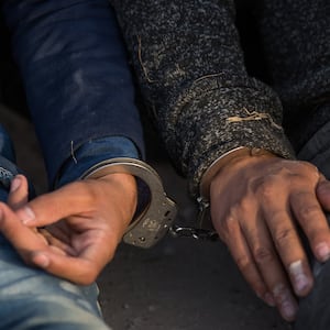 image of two men handcuffed to each other myth of criminal immigrant migrant caravan undocumented mexico central america