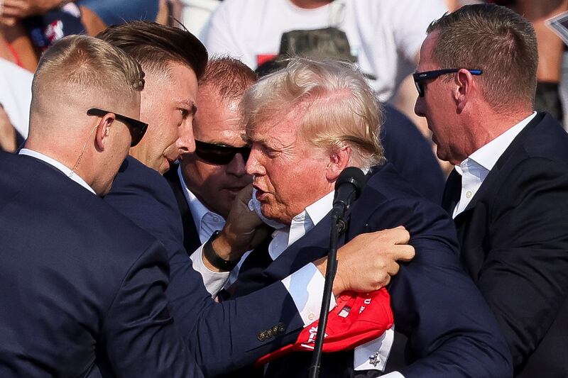 Secret Service agents rush to shield Donald Trump on stage