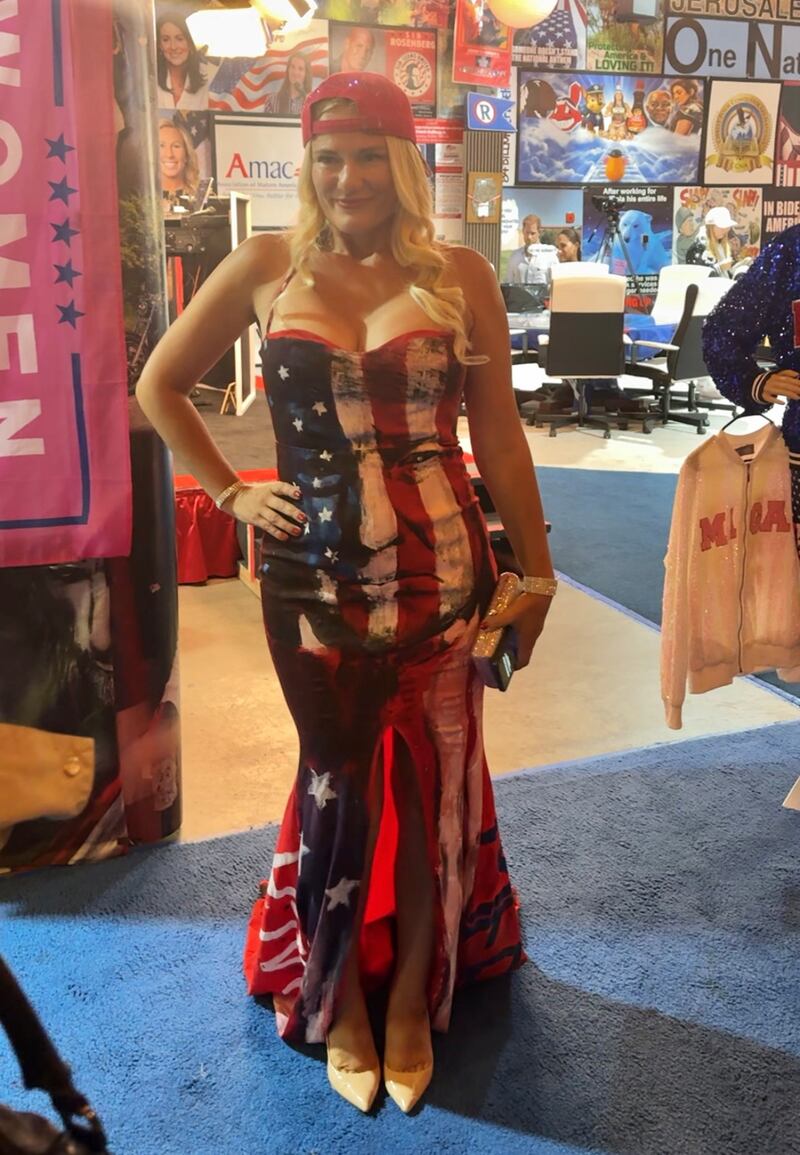 A woman wears an American flag-patterned gown featuring former president Donald Trump's face