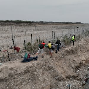 A group of irregular migrants' illegal crossings continue climbing up wire fences with their belongings in Eagle Pass, Texas, Mexico, on February 28, 2024.