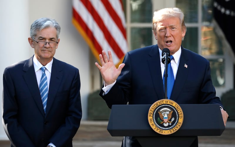 Donald Trump speaks on a podium next to Jerome Powell