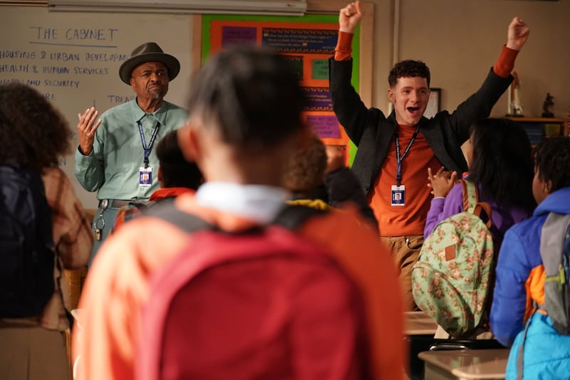 William Stanford Davis and Chris Perfetti cheer in front of a classroom