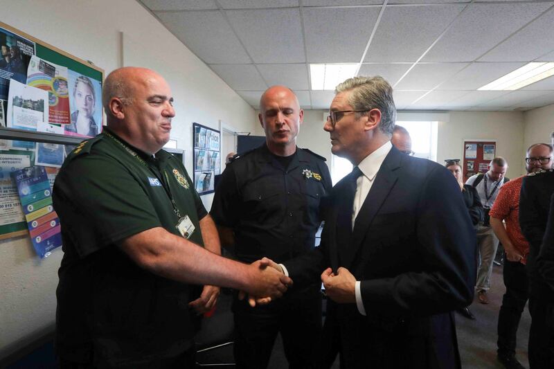 British Prime Minister Keir Starmer speaks to a member of the emergency personnel following the attack