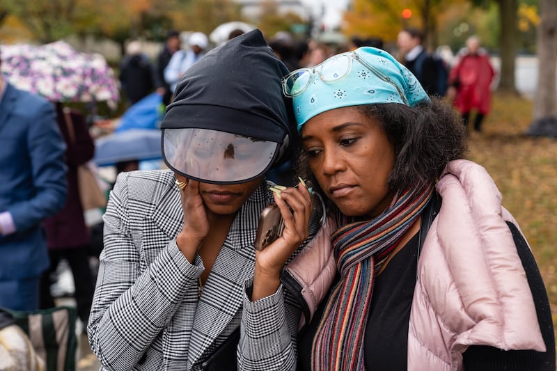 Two black women listening to oral arguments via telephone outside of the U.S. Supreme Court 