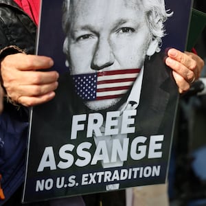 A demonstrator holds a sign that reads “FREE ASSANGE” and “NO U.S. EXTRADITION.”