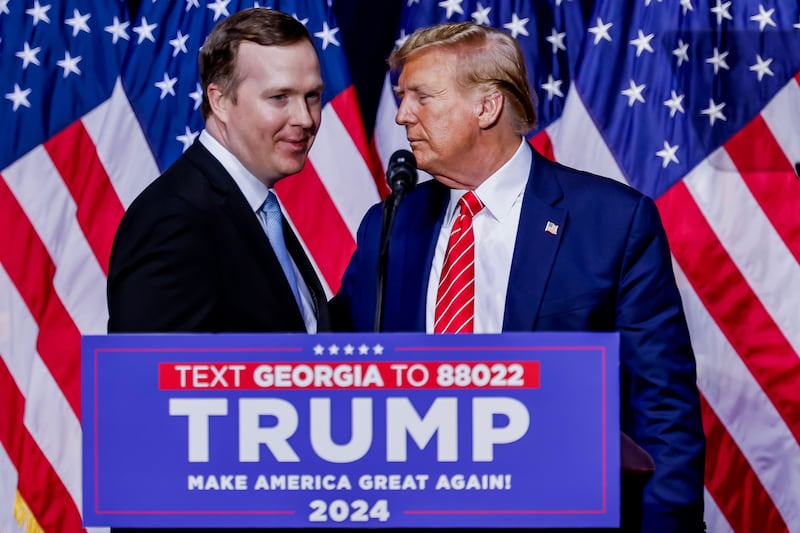 Brian Jack with Donald Trump in front of American flags and behind a lectern marked Georgia