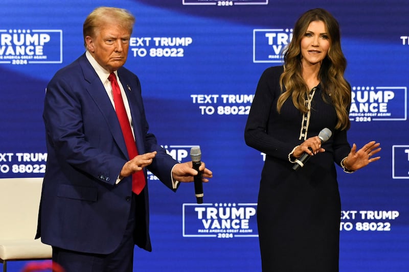 Republican presidential nominee former U.S. President Donald Trump and South Dakota Governor Kristi Noem dance during a town hall campaign event in Oaks, Pennsylvania, U.S., October 14, 2024.  REUTERS/David Muse