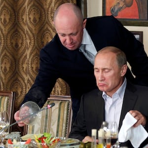 Yevgeny Prigozhin (L) assists Vladimir Putin during a dinner at the restaurant Cheval Blanc outside Moscow, Russia, Nov. 11, 2011. 