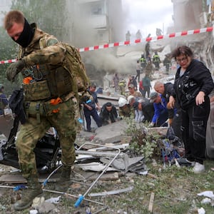 People remove debris while searching for survivors following the collapse of a section of an apartment block in the city of Belgorod, Russia, May 12, 2024. 