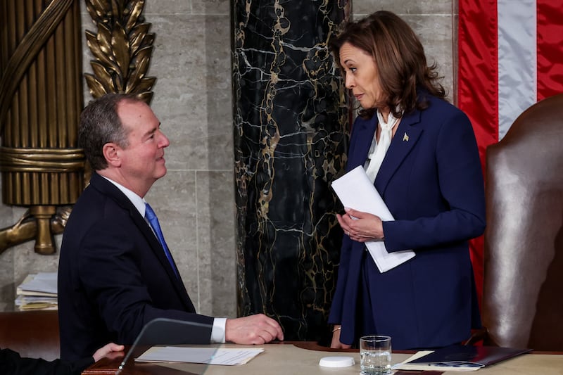 U.S. Vice President Kamala Harris speaks with U.S. Representative Adam Schiff. She is on the Speaker's dais in the House