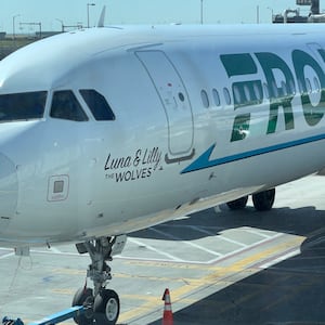 A photo of a Frontier Airlines plane parked at the gate.