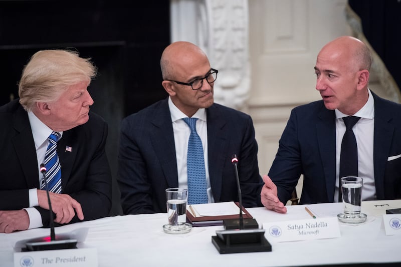 Donald Trump speaks with Satya Nadella, Chief Executive Officer of Microsoft, and Jeff Bezos, Chief Executive Officer of Amazon.