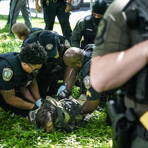 Police officers detain a demonstrator during a pro-Palestinian protest against the war in Gaza at Emory University on April 25, 2024, in Atlanta, Georgia.