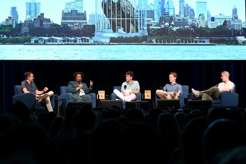 (L-R) Jon Favreau, Stacey Abrams, Jon Lovett, Tommy Vietor and Daniel Pfeiffer speak at a Pod Save America event in June. 