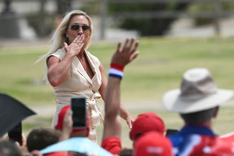 Marjorie Taylor Greene blows a kiss to a crowd at a rally