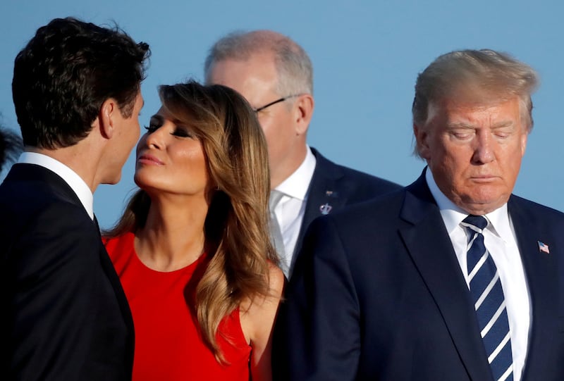 Melania Trump kisses Justin Trudeau and smiles, her husband behind scowls