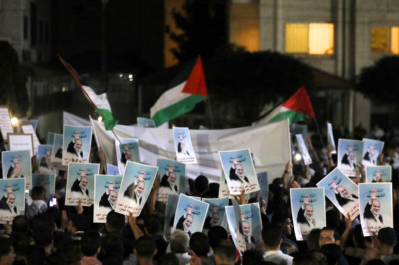 Protesters hold up photos of Ismail Haniyeh in Jordan