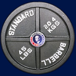 A weightlifting barbell plate with a Robert F. Kennedy Jr. campaign pin