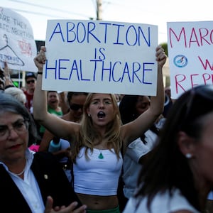 An abortion rights protester holds a sign as she demonstrates after the U.S. Supreme Court ruled in the Dobbs v Women’s Health Organization abortion case, overturning the landmark Roe v Wade abortion decision in Miami.