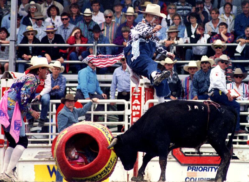 Rodeo Clown Daren Tuftin jumps over a Mexican fighting bull while fellow clowns Kelly La Coste, in barrell, and Ryan Byrn distract the animal during the 1995 Calgary Stampede in Calgary, Alberta.