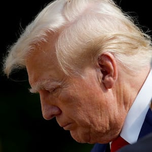 Donald Trump looks down while walking at Arlington National Cemetery.